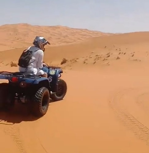 a tourist with his Quad in the Dunes of Merzouga enjoying the Adventure