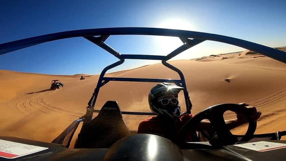 a tourist racing with the quad in the Dunes of Merzouga Sahara