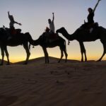 Three tourists from US experiencing the camel trek in the dunes of Merzouga